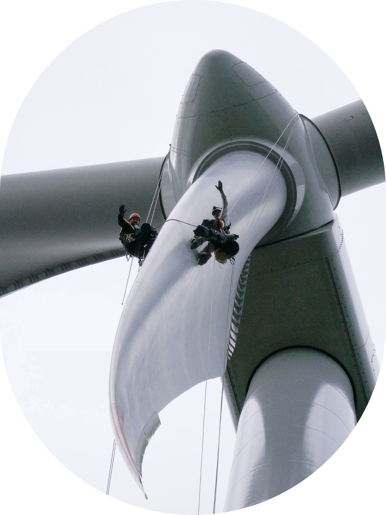 Rope access contractors waving from offshore wind turbine